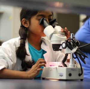 Young girl using a microscope