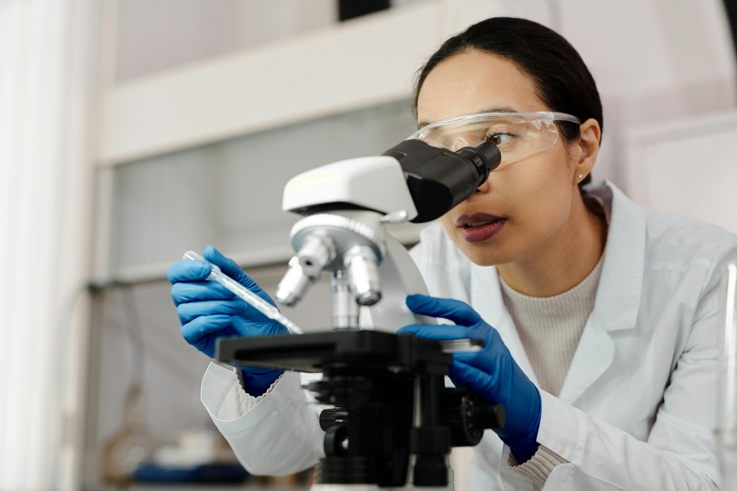 Researcher using a microscope in the lab.